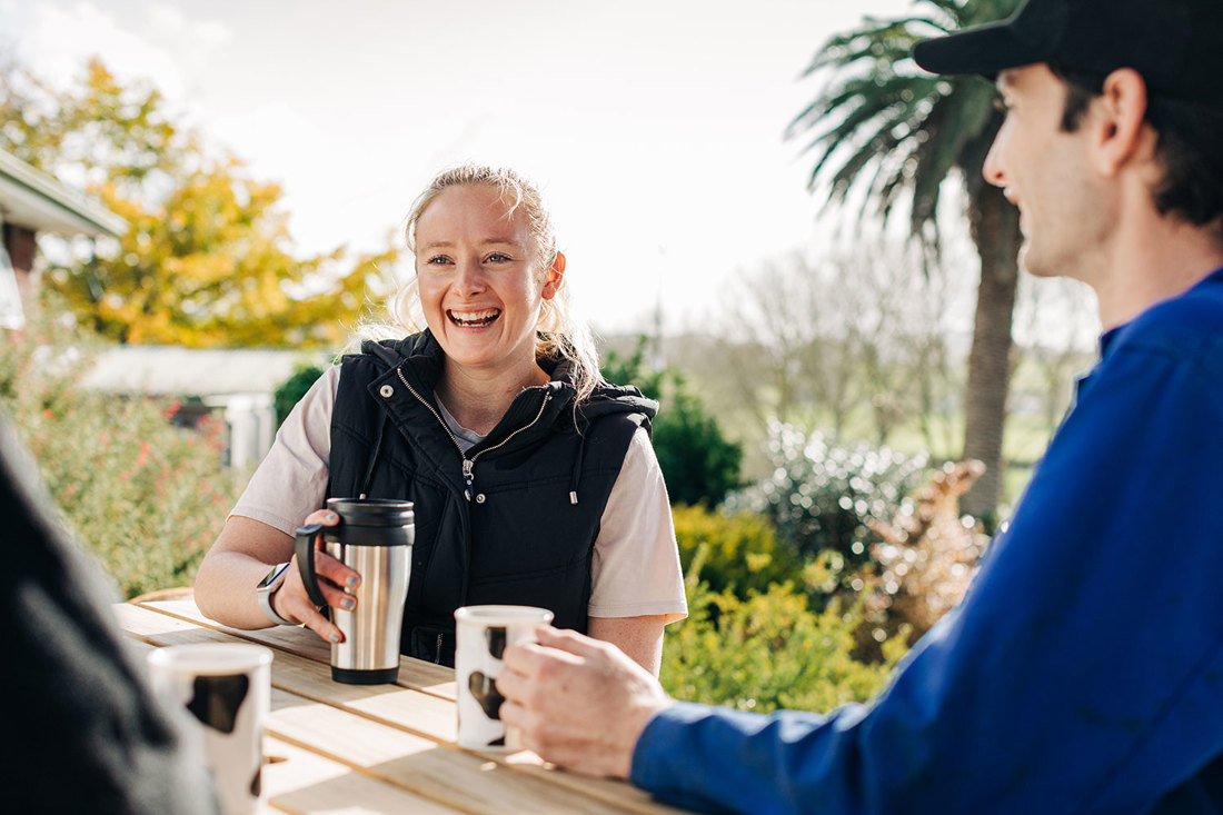 Three farm workers sitting outside, catching up over a cup of coffee