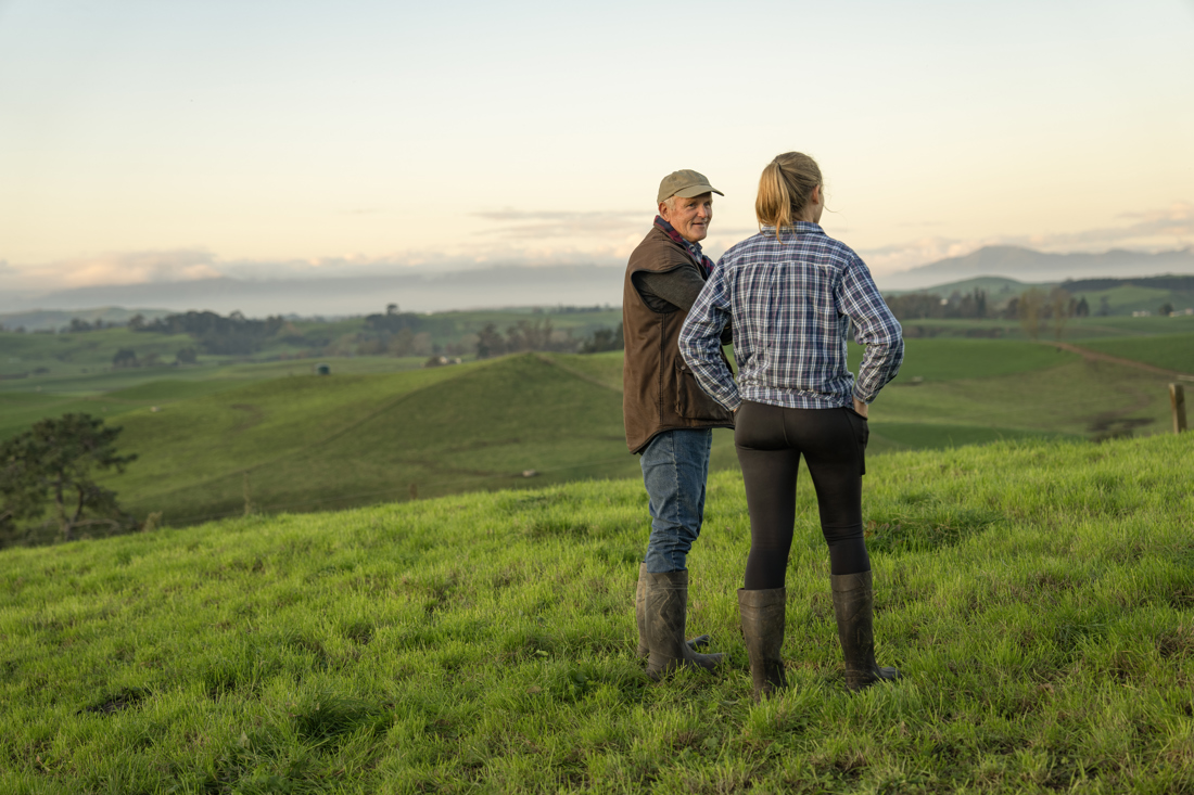 A man and woman standing in a field discussing something