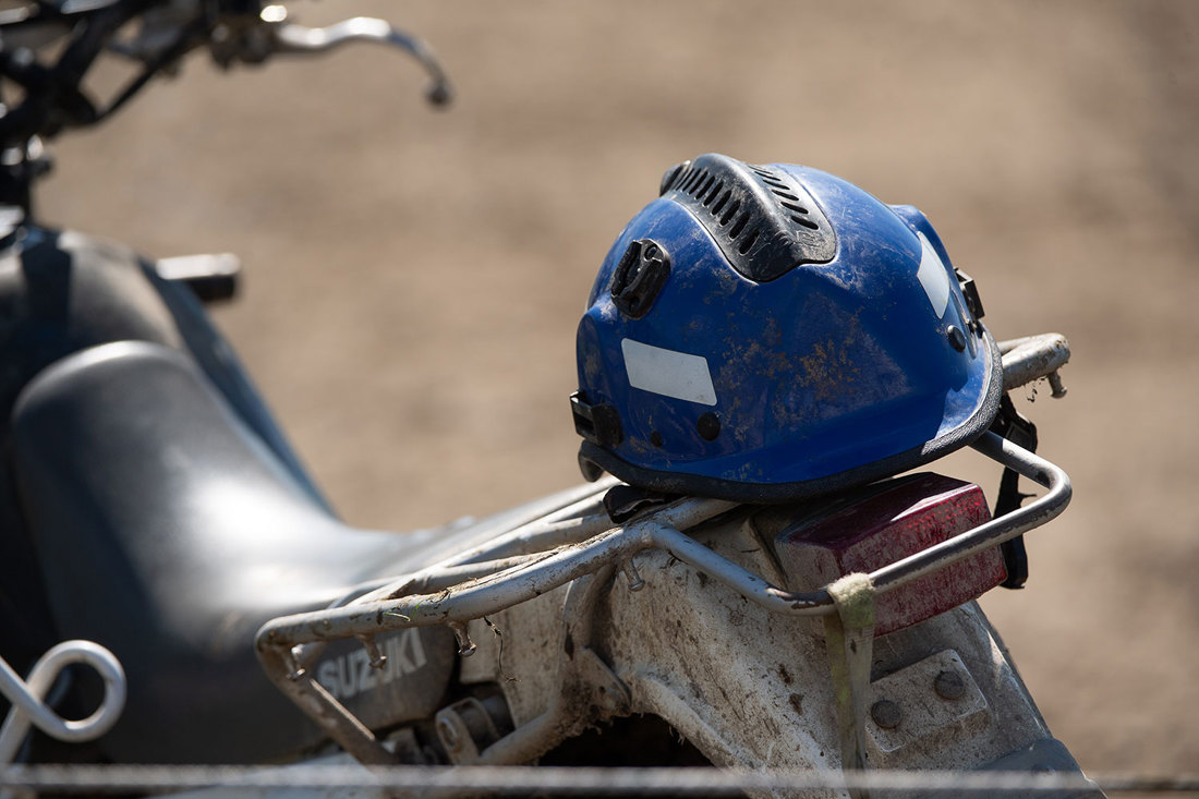 A close-up of a blue helmet on a farm motorcycle