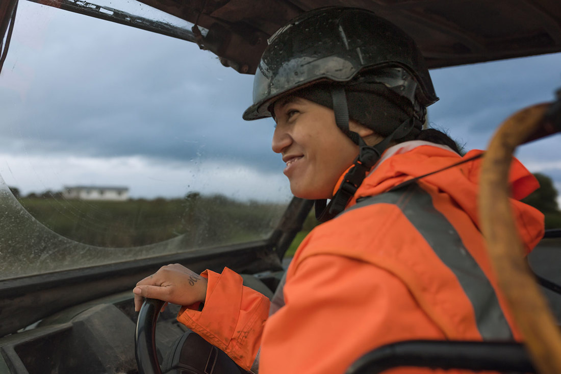 A close-up of a farm employee drivng a farm vehicle