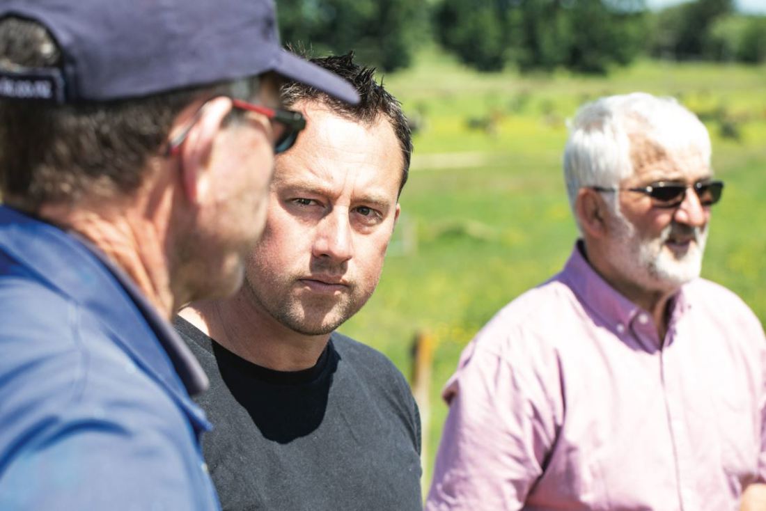 Close up of three dairy farmers talking at a DairyNZ-led event