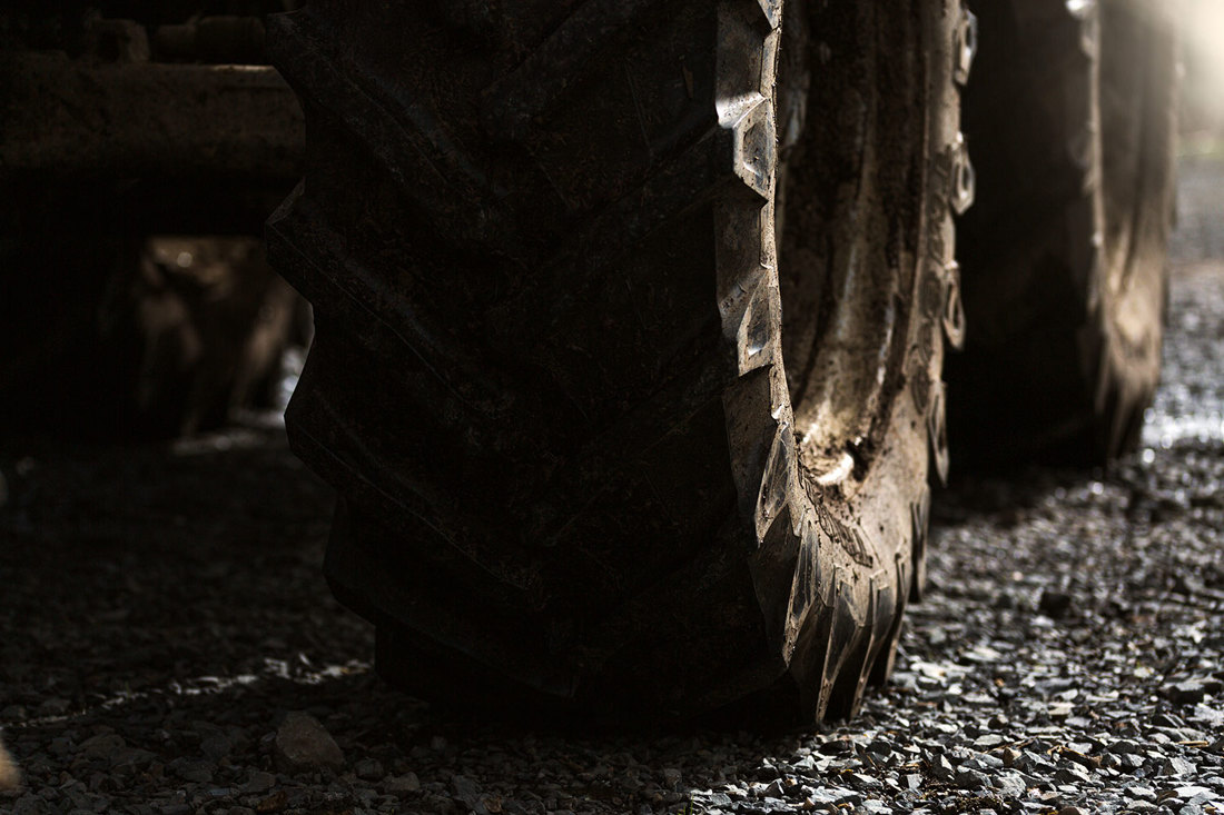 A close-up of a tractor wheel on gravel