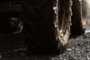 A close-up of a tractor wheel on gravel