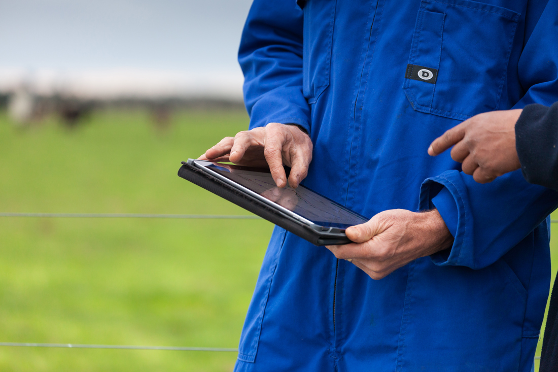 A man wearing a blue protective equipment explaining something from an Ipad