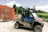 Dairy farm workers in a muddy all terrain vehicle in the farm yard