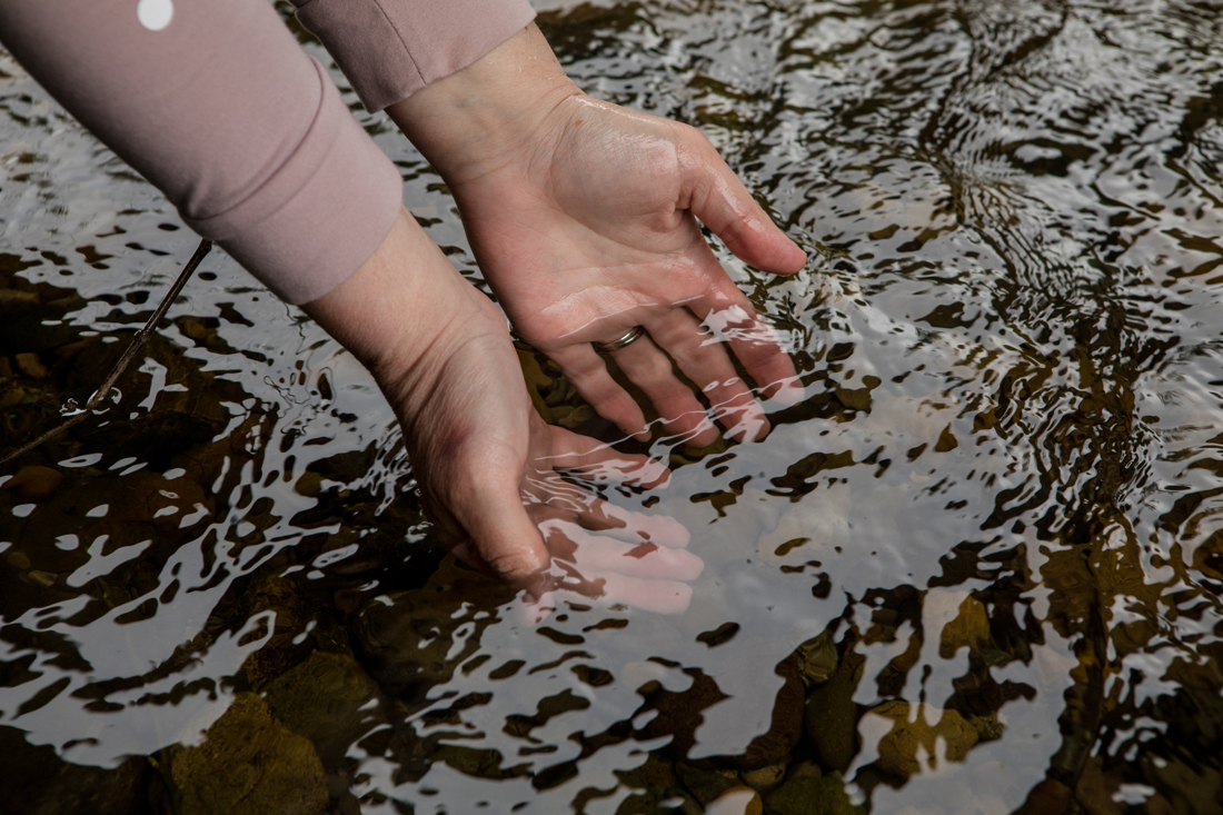 Two hands holding a brimming handful of water
