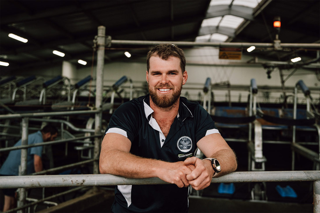 A member of New Zealand Young Farmers standing in a farm dairy.